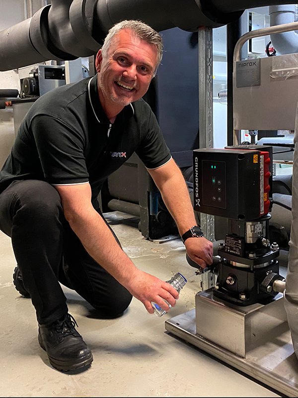 Salgssjef John Kåre Krokene tar en vannprøve fra et anlegg på Fyrstikktorget i Oslo.